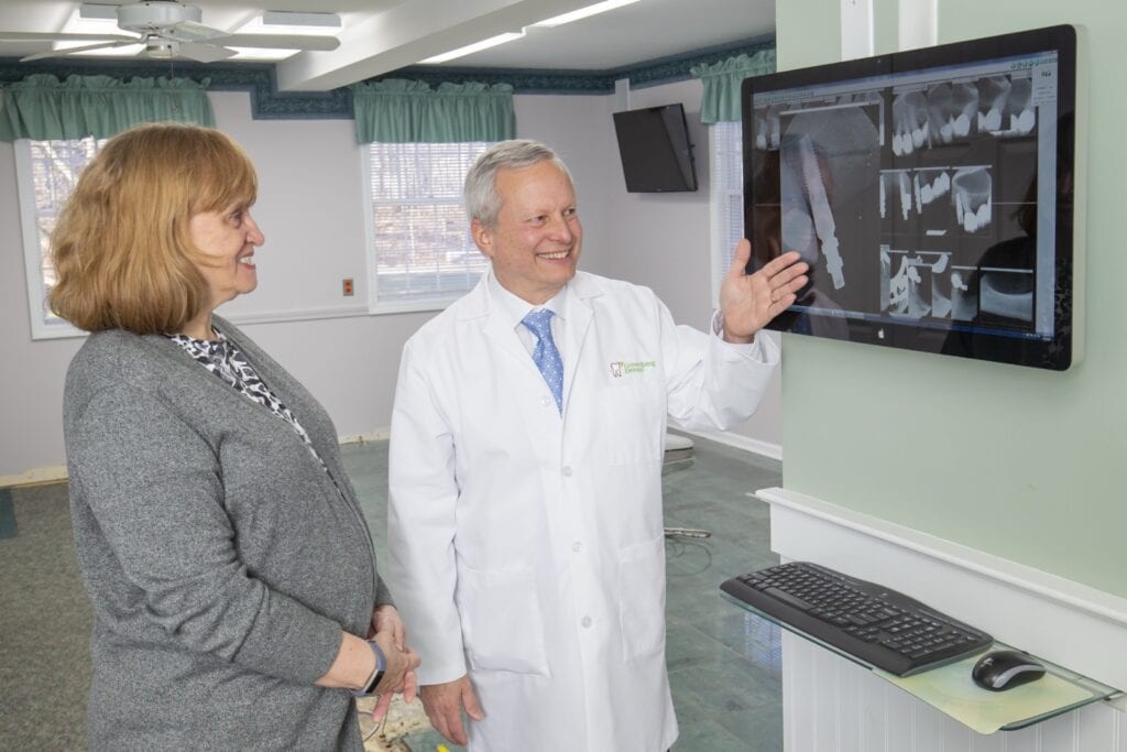 Dr. Randy Greenberg shows a patient an implant x-ray on a screen
