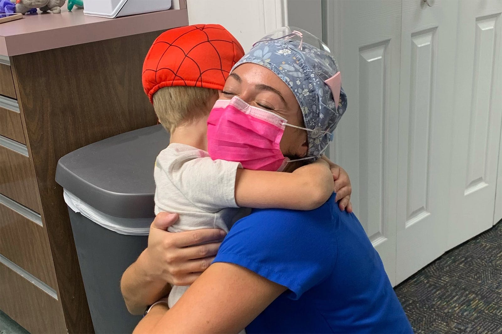 A child gives a hug to a dental assistant