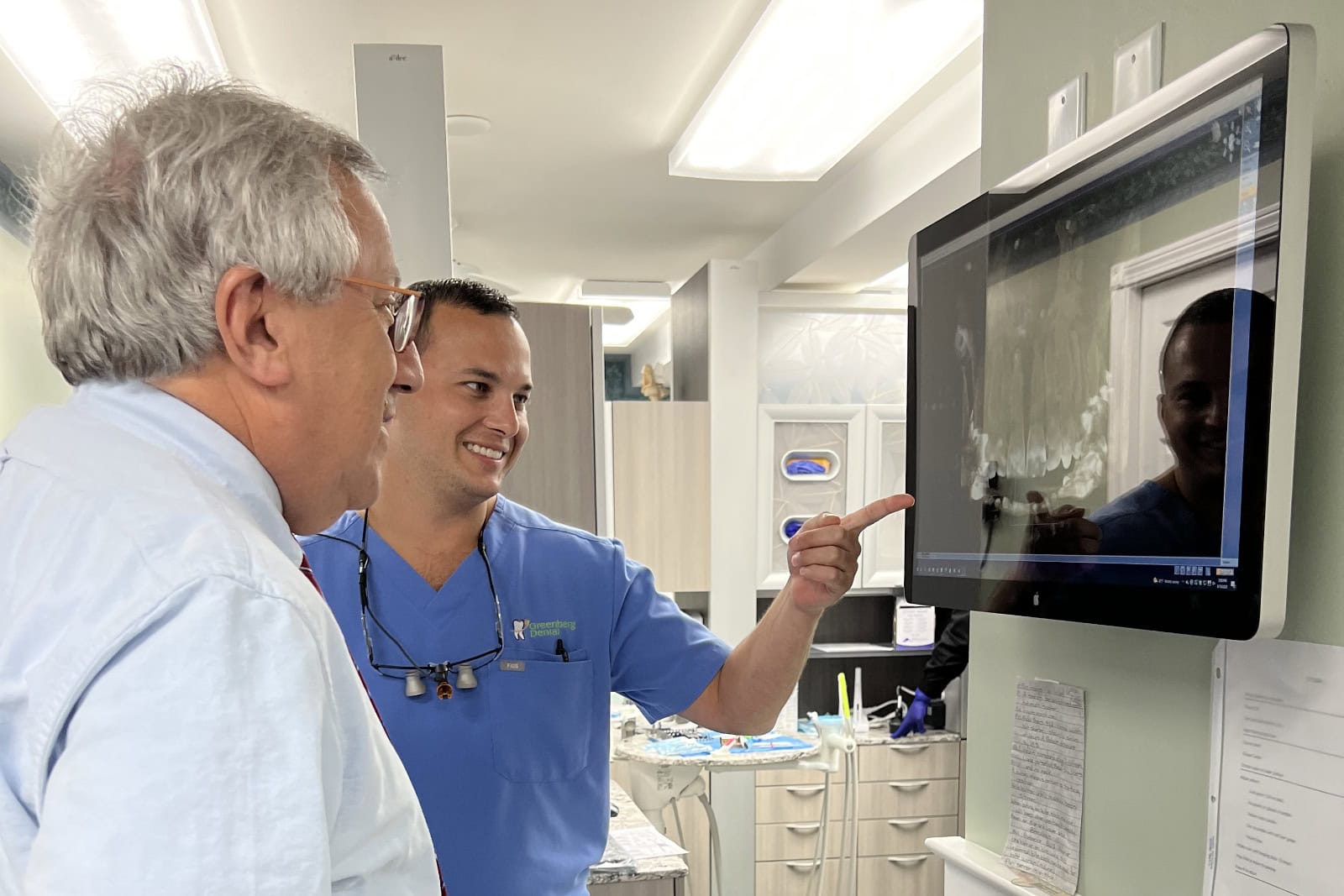 Dr. Stephen Greenberg shows a patient a 3D teeth model