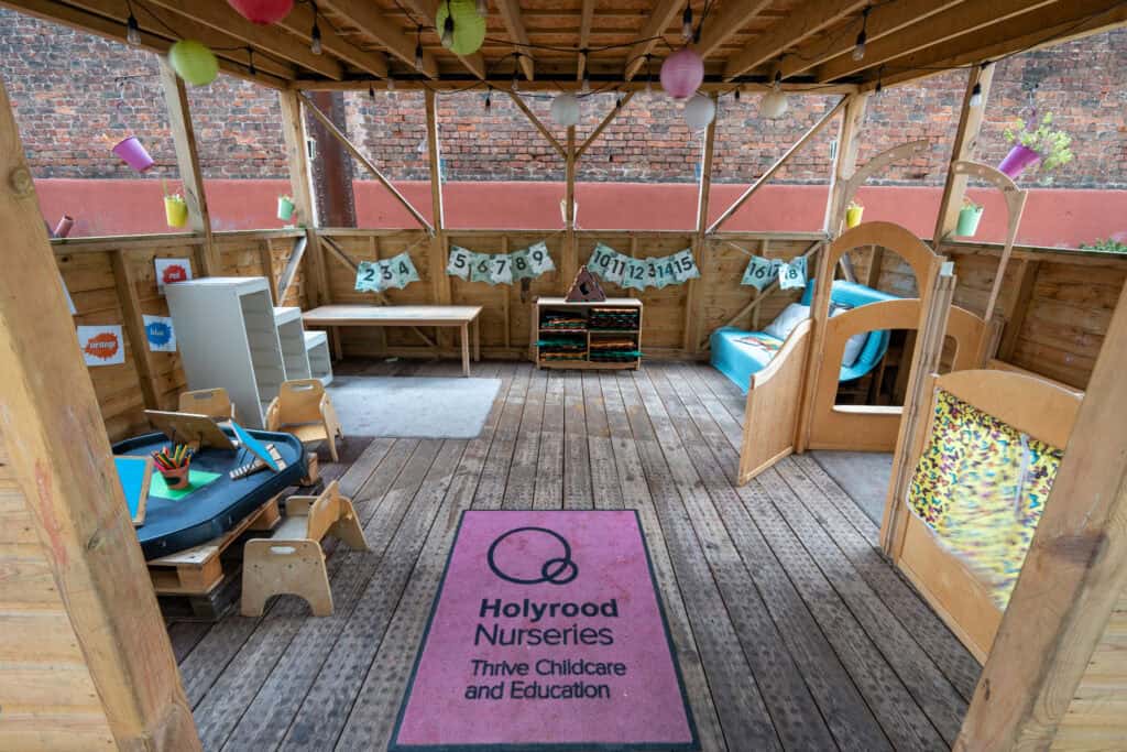Bright and welcoming nursery play area at Holyrood Nursery Princes Dock with wooden furniture and colourful decorations.