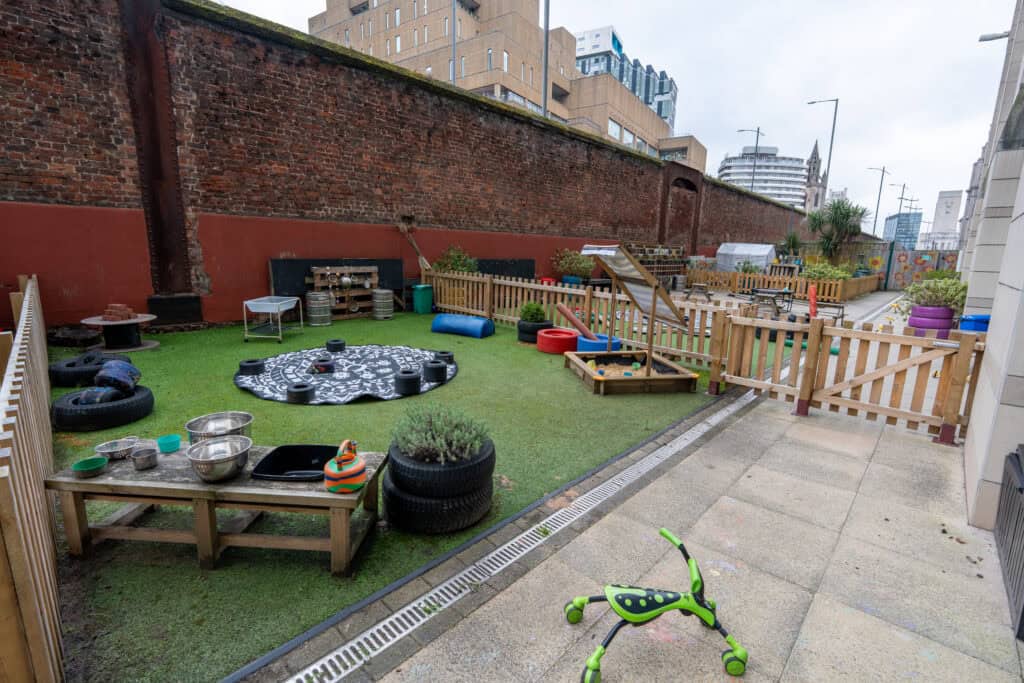 Outdoor play area at Holyrood Nursery Princes Dock, featuring safe, engaging equipment and natural surroundings for children's development.