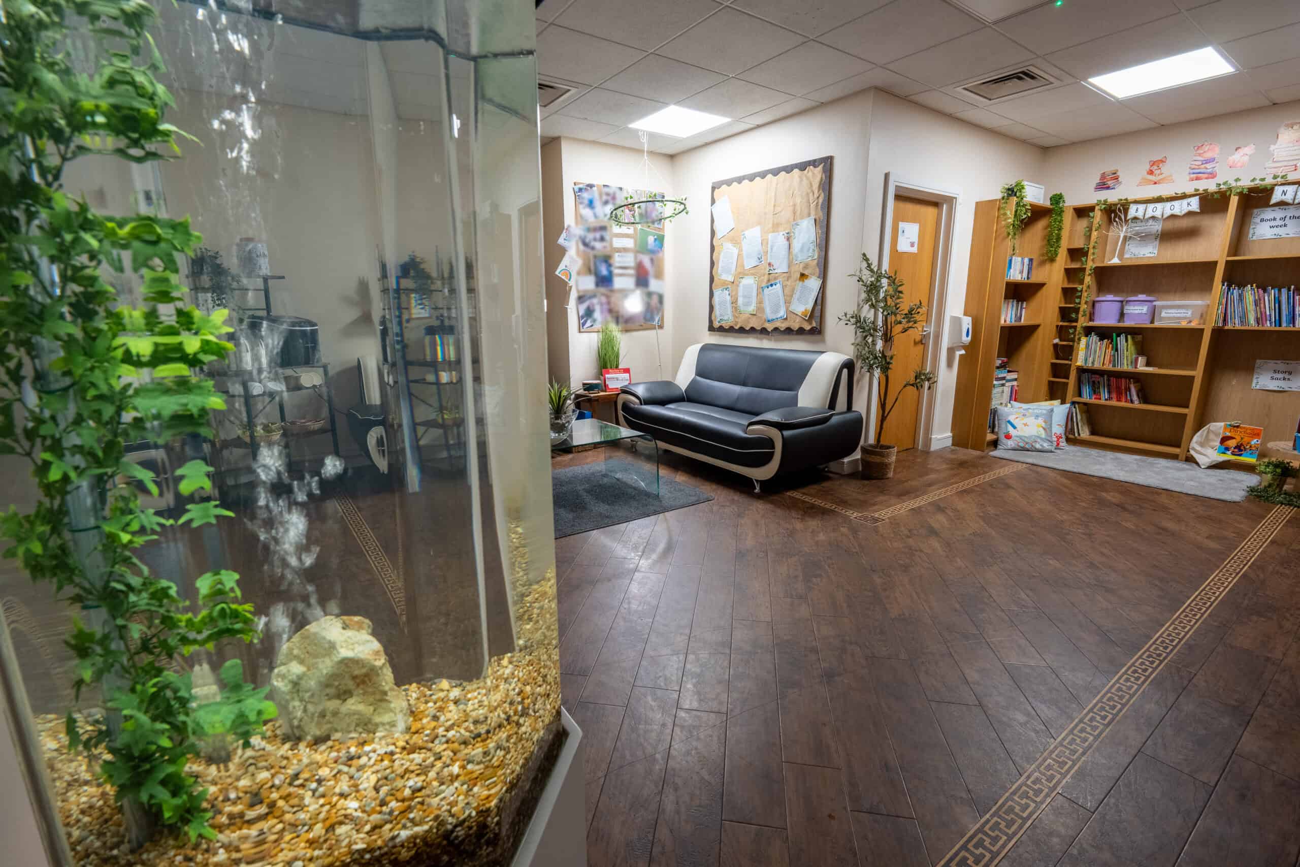 Bright and welcoming nursery lounge area with bookshelves and comfortable seating.