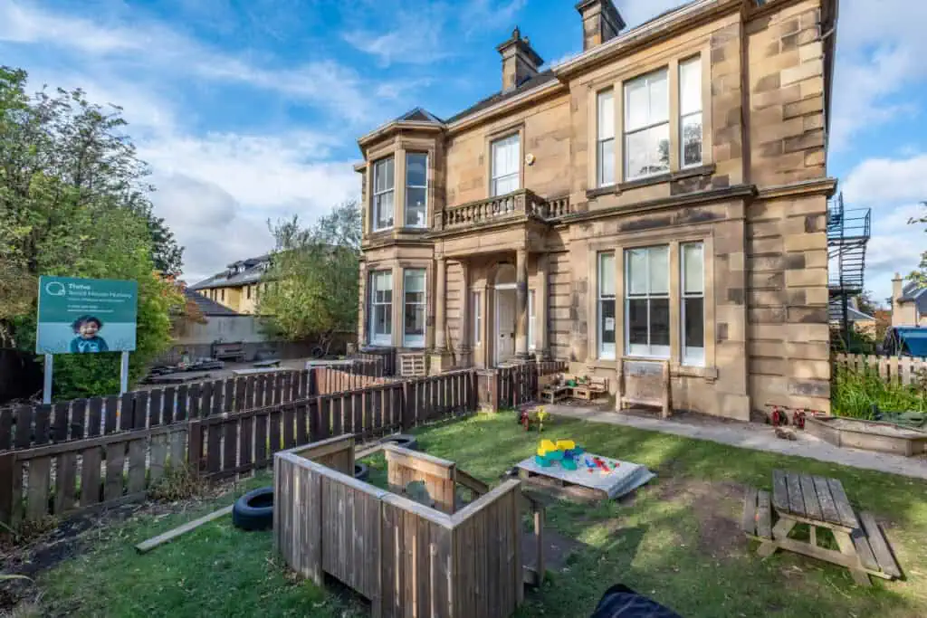 Bright, welcoming childcare centre with outdoor play area at Thrive Childcare, Teviot House Nursery, showcasing a fun and safe environment for children's learning and development in a historic building.