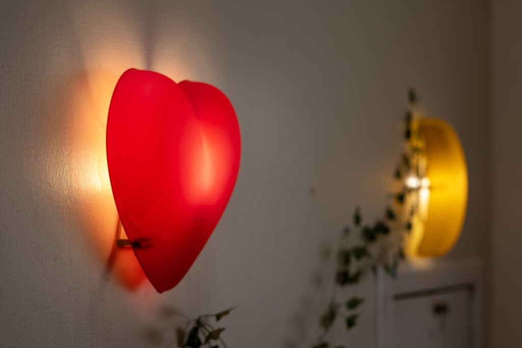 Bright red heart-shaped wall light emitting warm glow at Thrive Childcare, creating a cosy atmosphere for children’s play and learning environments. Ideal for childcare settings and nursery decor.
