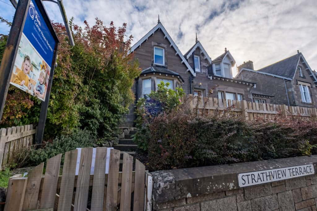 Bright, historic Victorian-style house used as Thrive Childcare, situated on Strathview Terrace in a scenic residential area with lush greenery and clear sky.