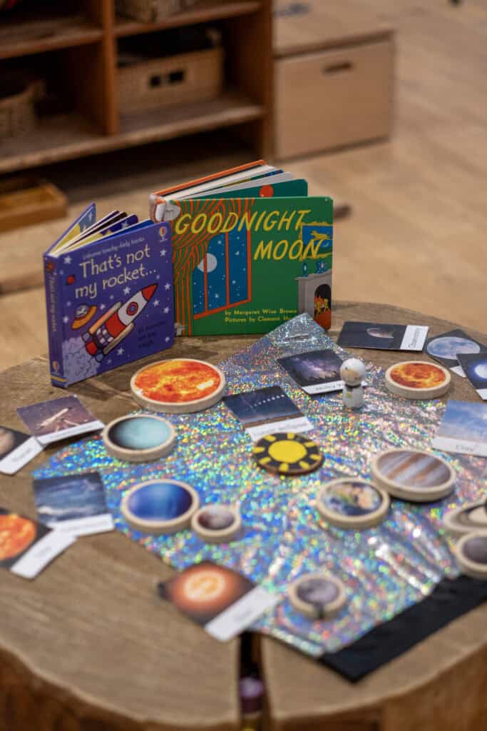 Bright children's space with books, educational materials, and space-themed toys promoting early learning and curiosity at Thrive Childcare.