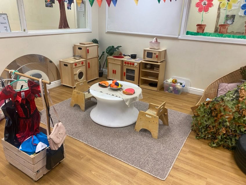 Play area with child-sized furniture, toys, and educational activities at Holyrood Nursery Swinton, designed to promote learning and social skills in young children.