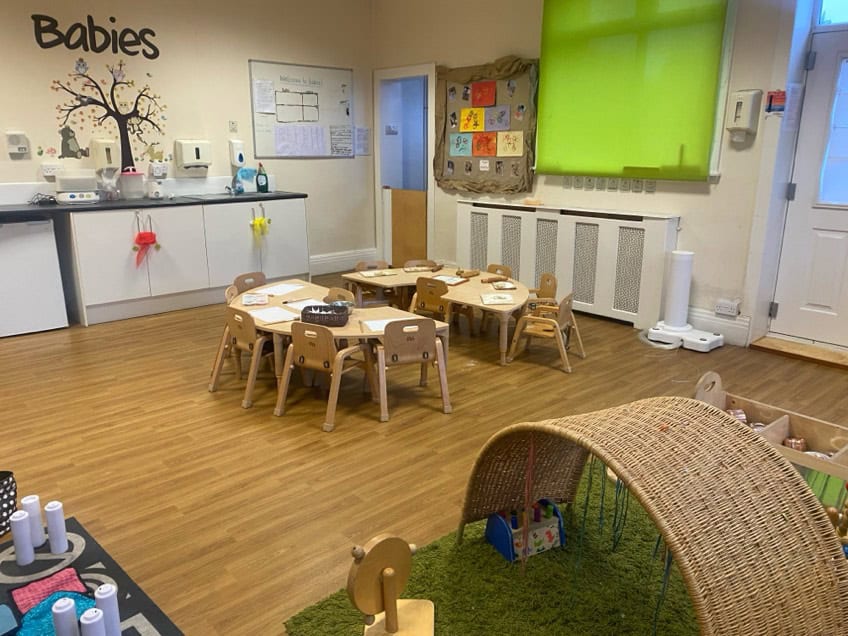 Child-friendly nursery room with small tables and chairs for early learning.