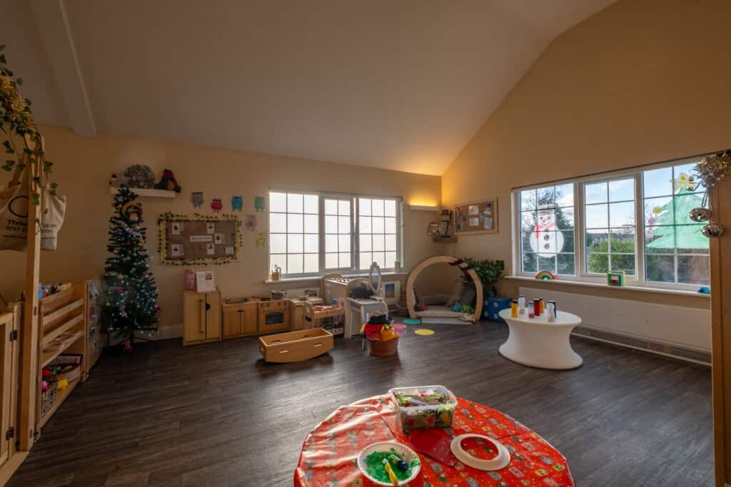 Bright and welcoming indoor playroom at Corner House Astbury, part of Thrive Childcare, featuring toys, play equipment, and a cosy environment for children's development and fun.