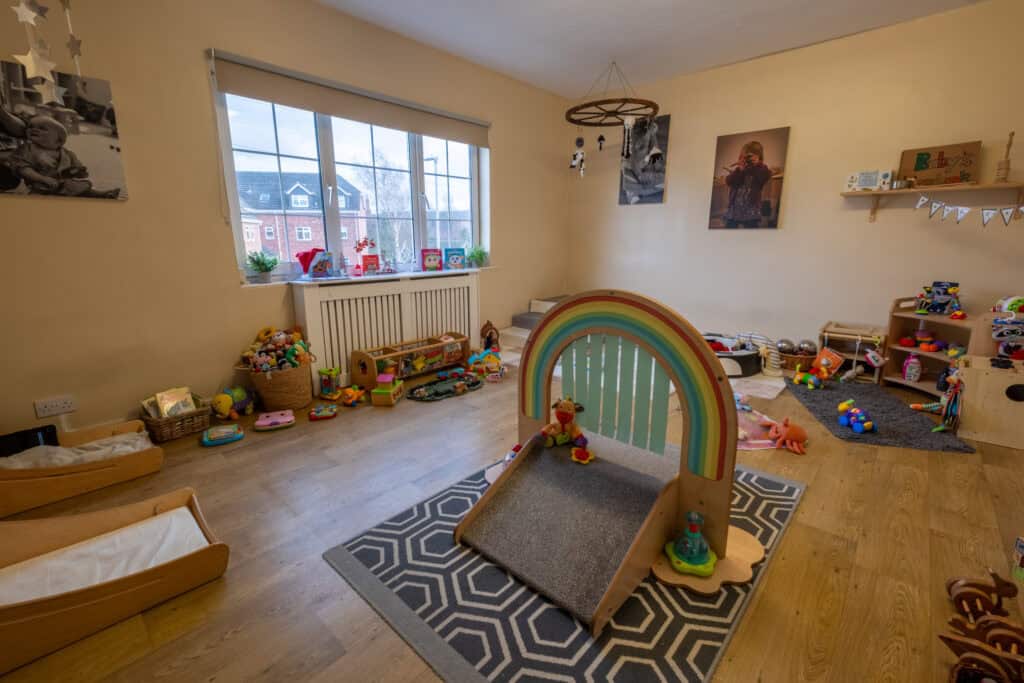 Child-friendly play area with toys, a rainbow arch, and cozy space for young children.