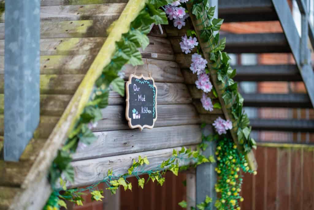 Outdoor play area at Thrive Grosvenor House with decorative flowers and a chalkboard sign.