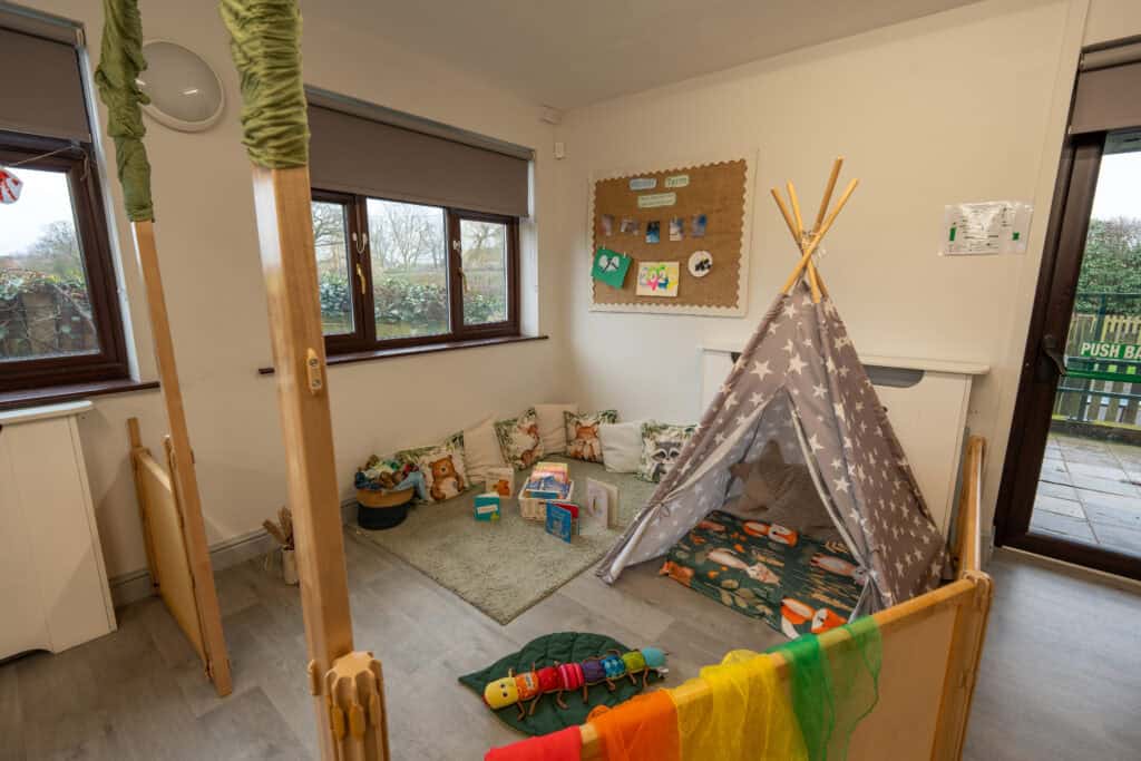 An inviting indoor play area at Thrive Childcare, Grosvenor House, featuring a cozy teepee, soft cushions, and engaging toys for young children.
