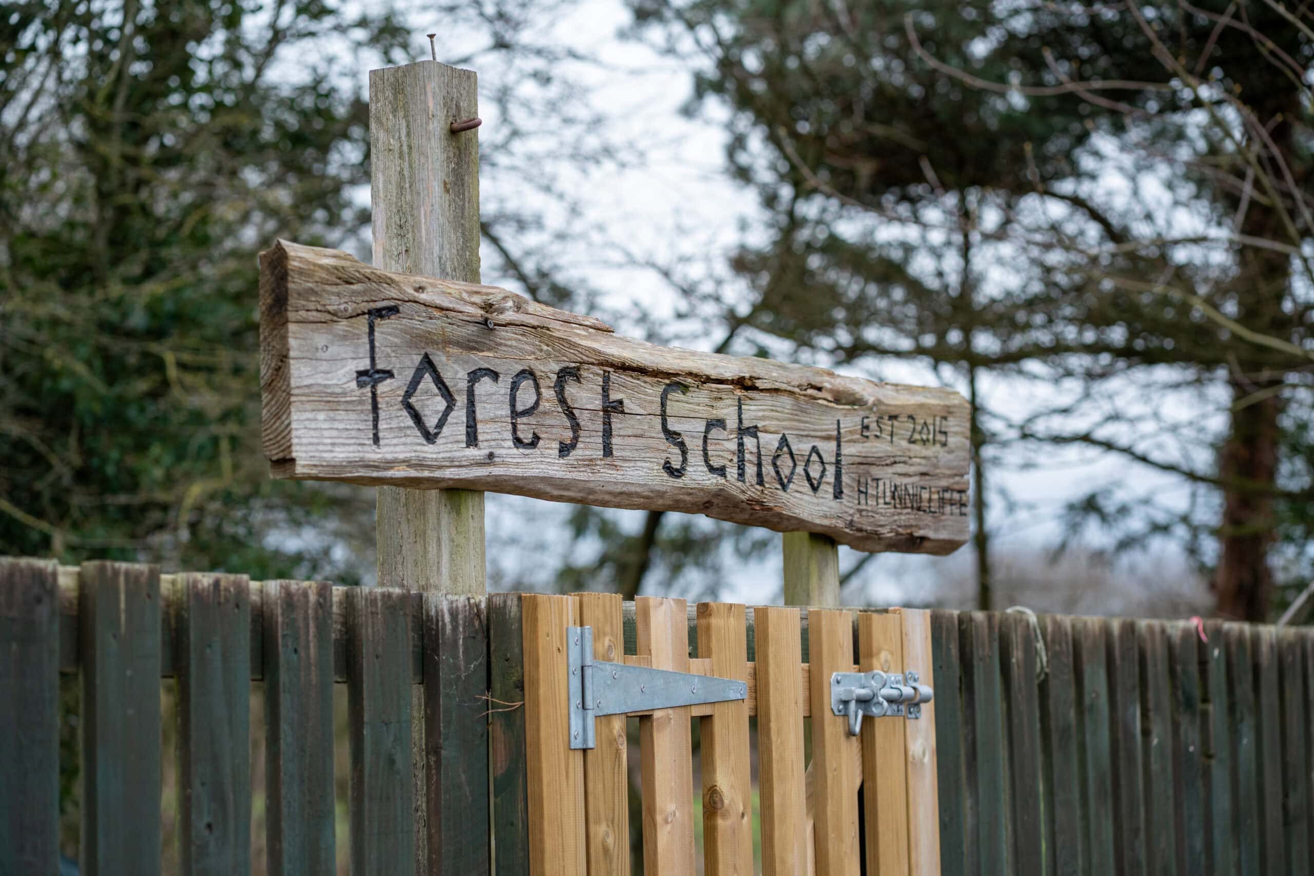 Outdoor forest school sign with rustic wooden design at Thrive Grosvenor House childcare centre.