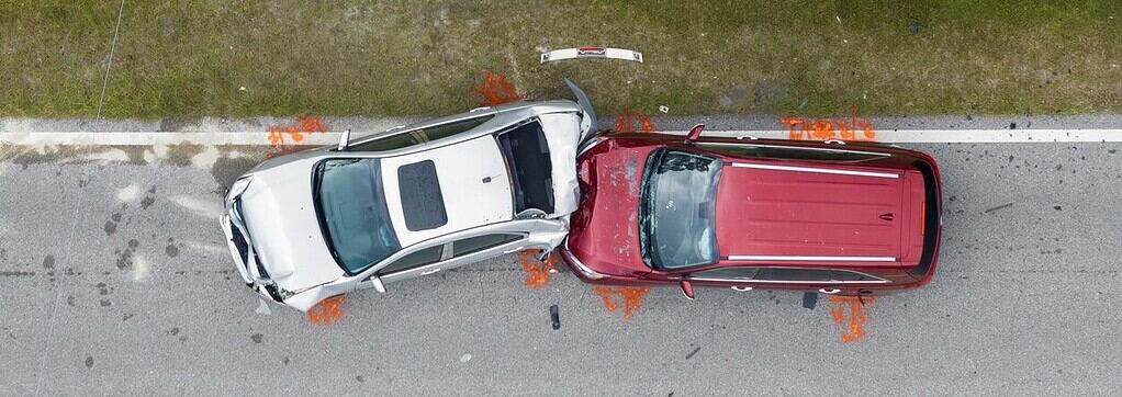 Damaged white and red SUVs after a car accident, with police markings on the road, illustrating the importance of legal representation in personal injury and car accident cases.