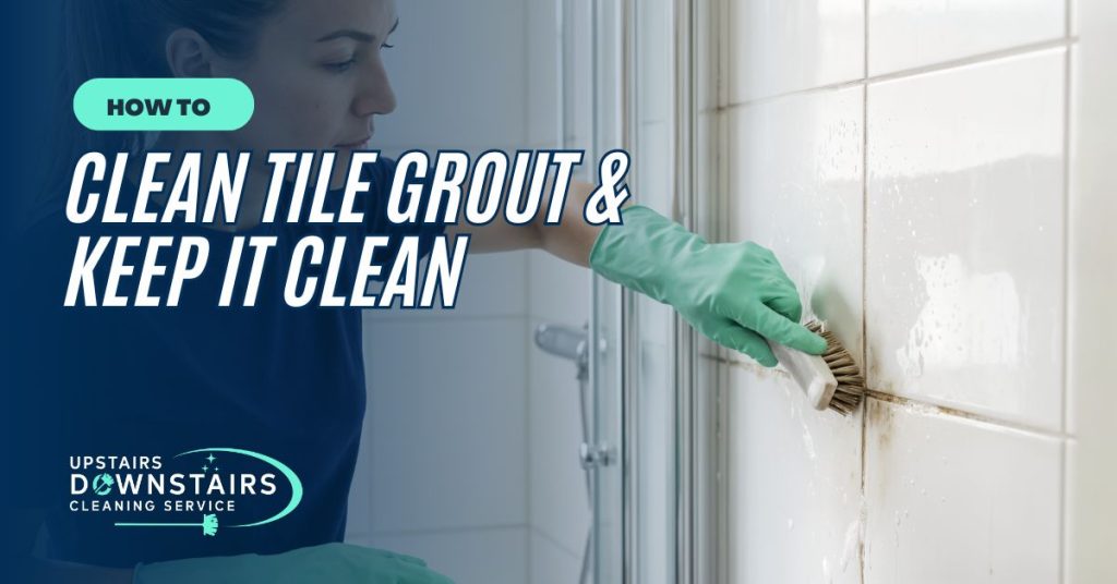 How To Clean Grout - Upstairs Downstairs Cleaning Service Woman wearing green gloves scrubbing tiled wall with a brush for grout cleaning; overlay text reads 'How to Clean Tile Grout & Keep It Clean' (upstairs downstairs cleaning service)
