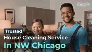 A smiling house cleaner with a clipboard in a modern kitchen.
