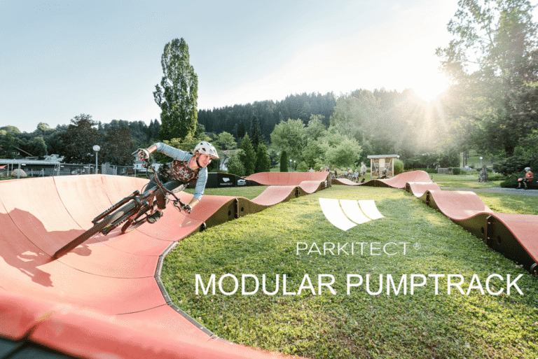 Abenteuerlicher Mountainbike-Fahrer auf modulärem Pumptrack in grünem Park.