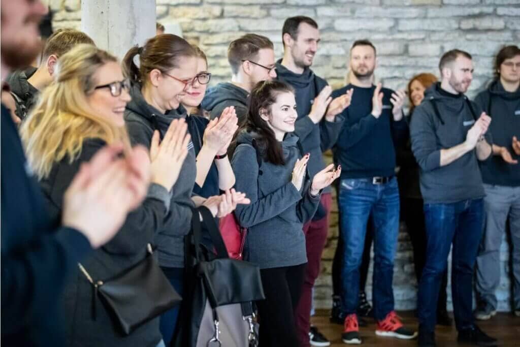 A equipe da Veriff toda junta rindo e aplaudindo