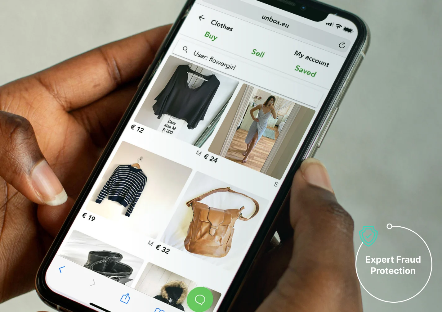 a hand holding a phone with a screen showing a picture of clothes