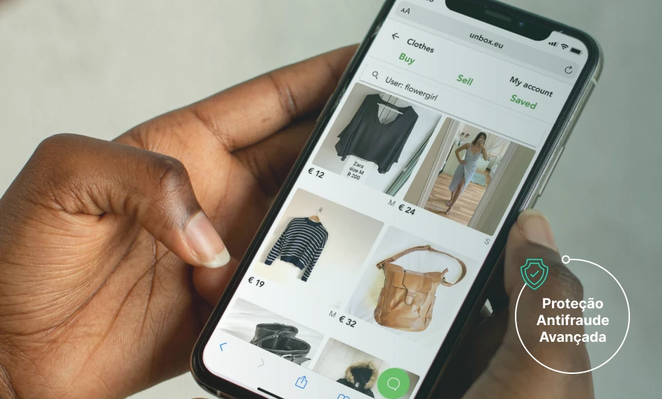 a hand holding a phone with a screen showing a picture of clothes