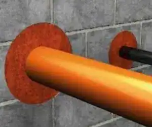 Orange pipe through a wall fire barrier seal