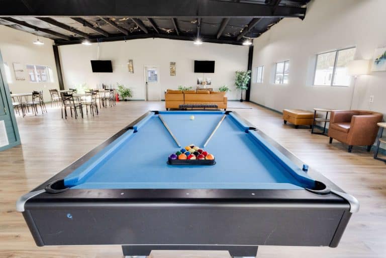 Vinton LA RV Park Vinton LA RV Park recreation room in Vinton, Texas with blue pool table, racked balls, cues, seating, and TVs in background.