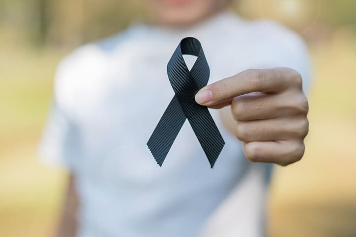 Man holding up cancer ribbon