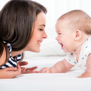 Beautiful mother and son are lying in bed and looking at each other.