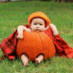 a baby in a pumpkin in the grass