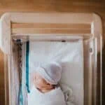 a baby sleeping in a hospital bassiner