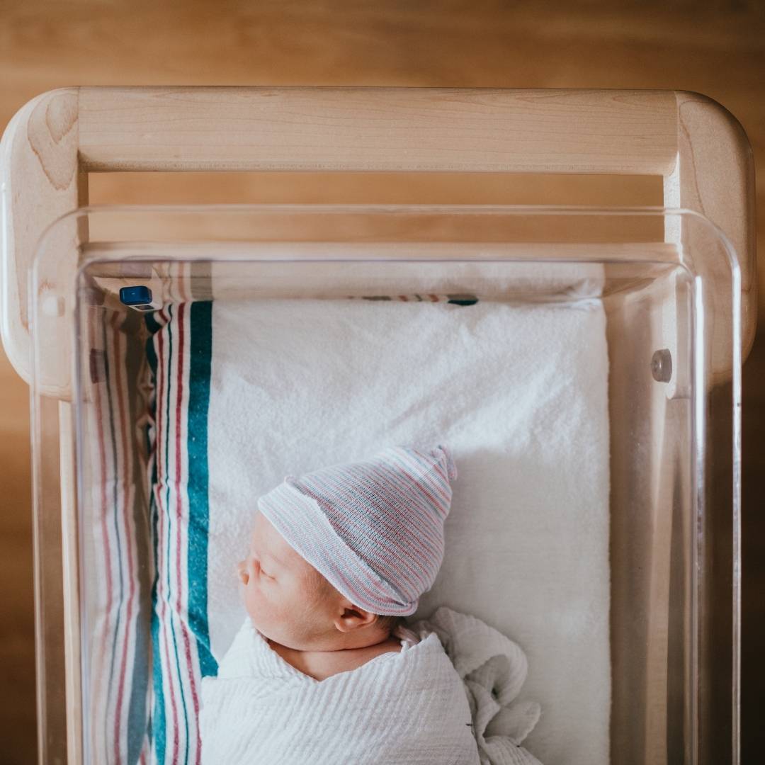 a baby sleeping in a hospital bassiner