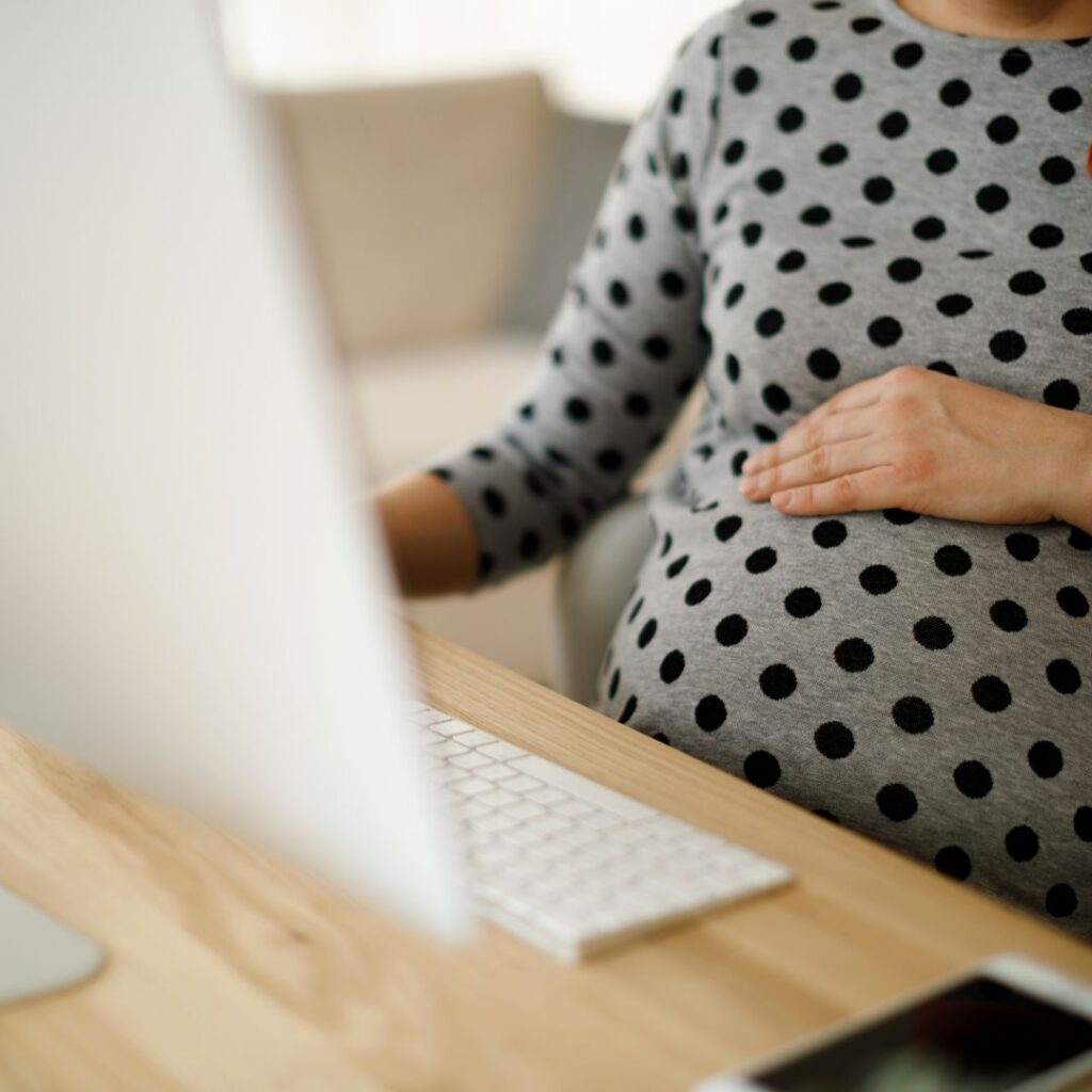 pregnant mom in polka dot shirt working on the computer