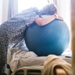 laboring person leaning over an exercise ball