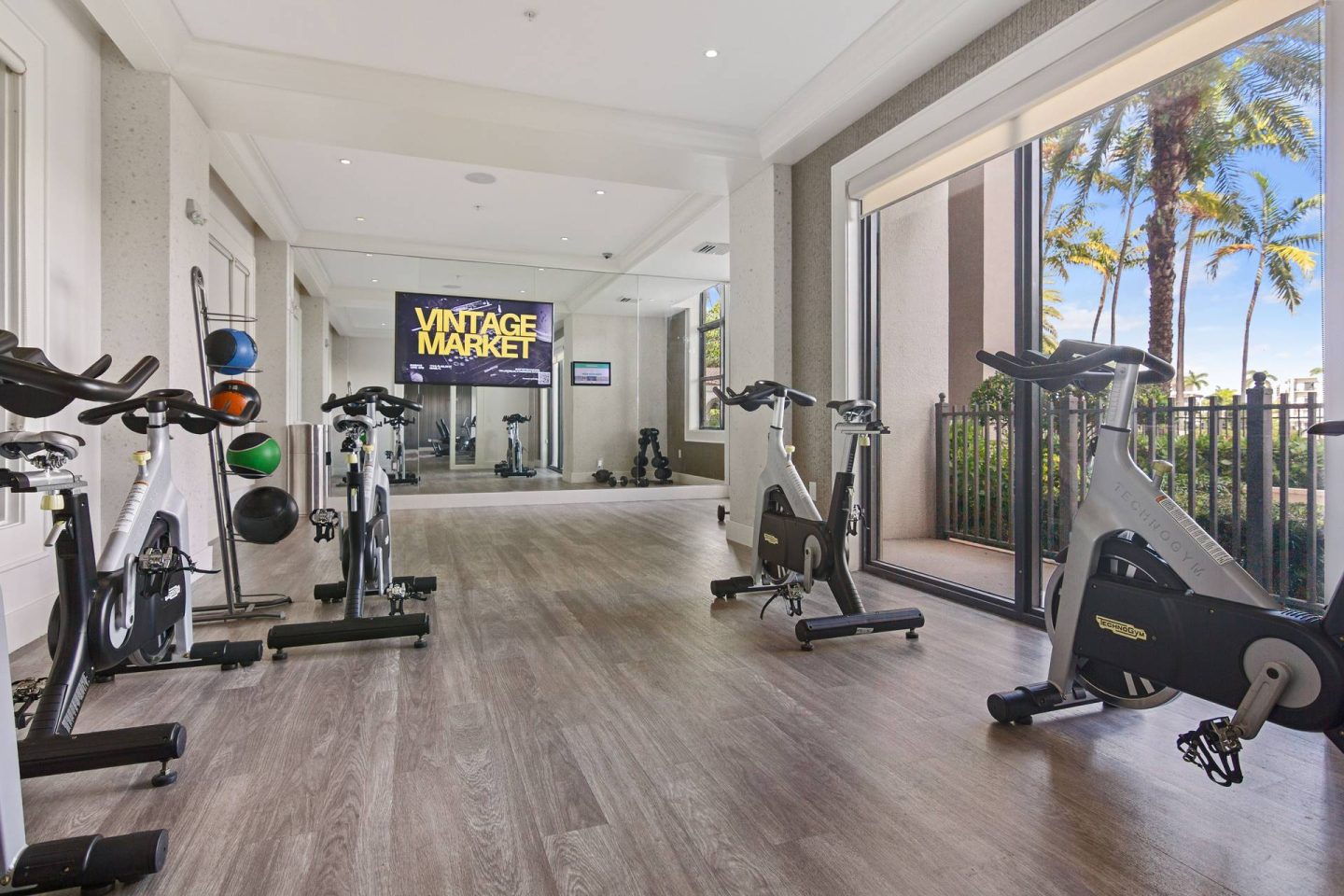 A gym with a variety of exercise equipment including treadmills, stationary bikes, and weight machines.