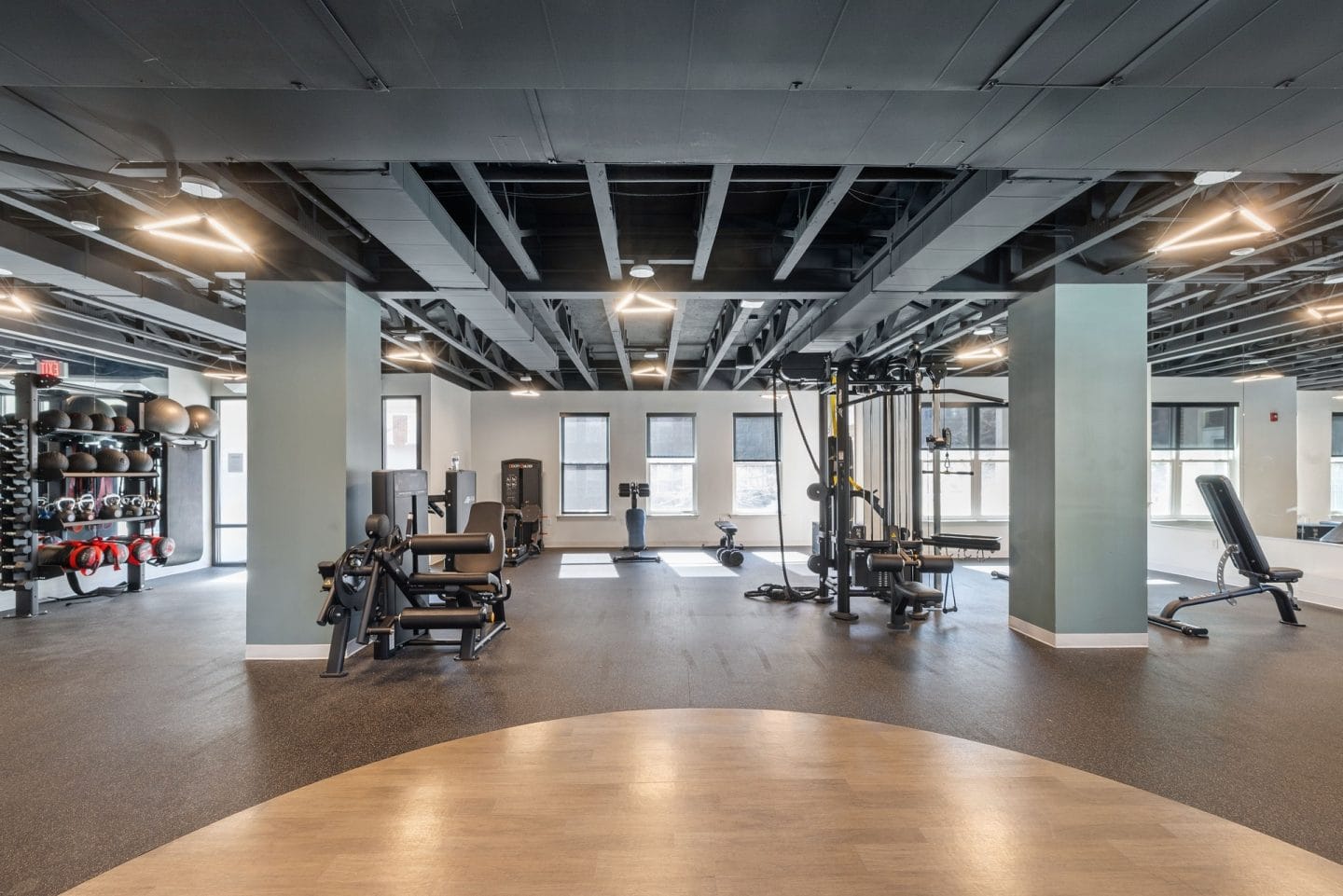 A gym with a variety of equipment including weights and cardio machines.