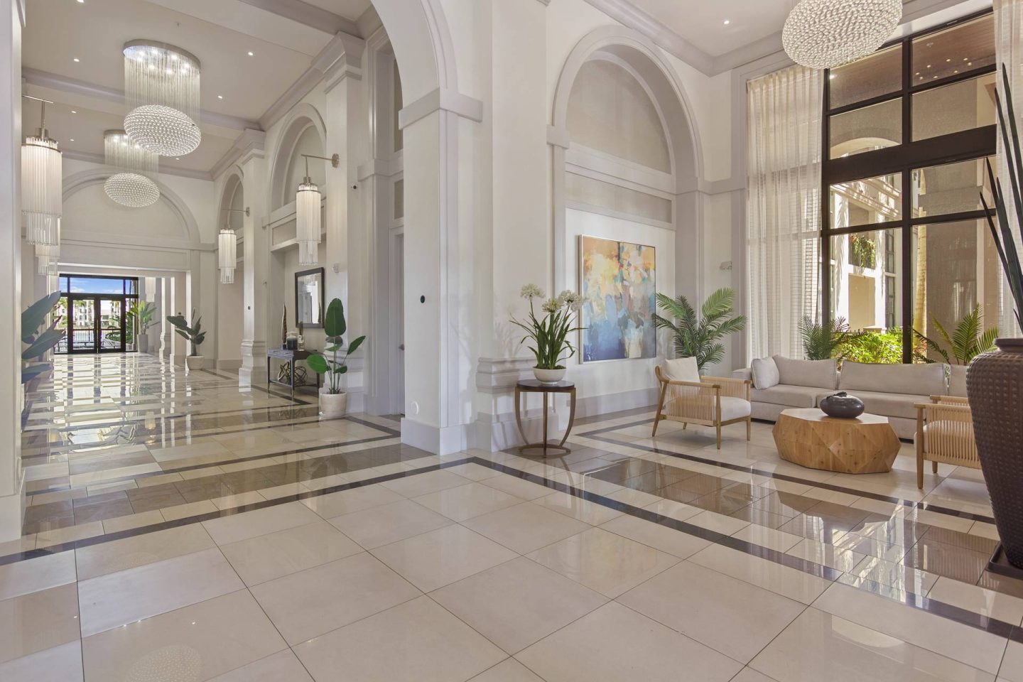 A spacious, well-lit lobby with a marble floor and elegant furniture.