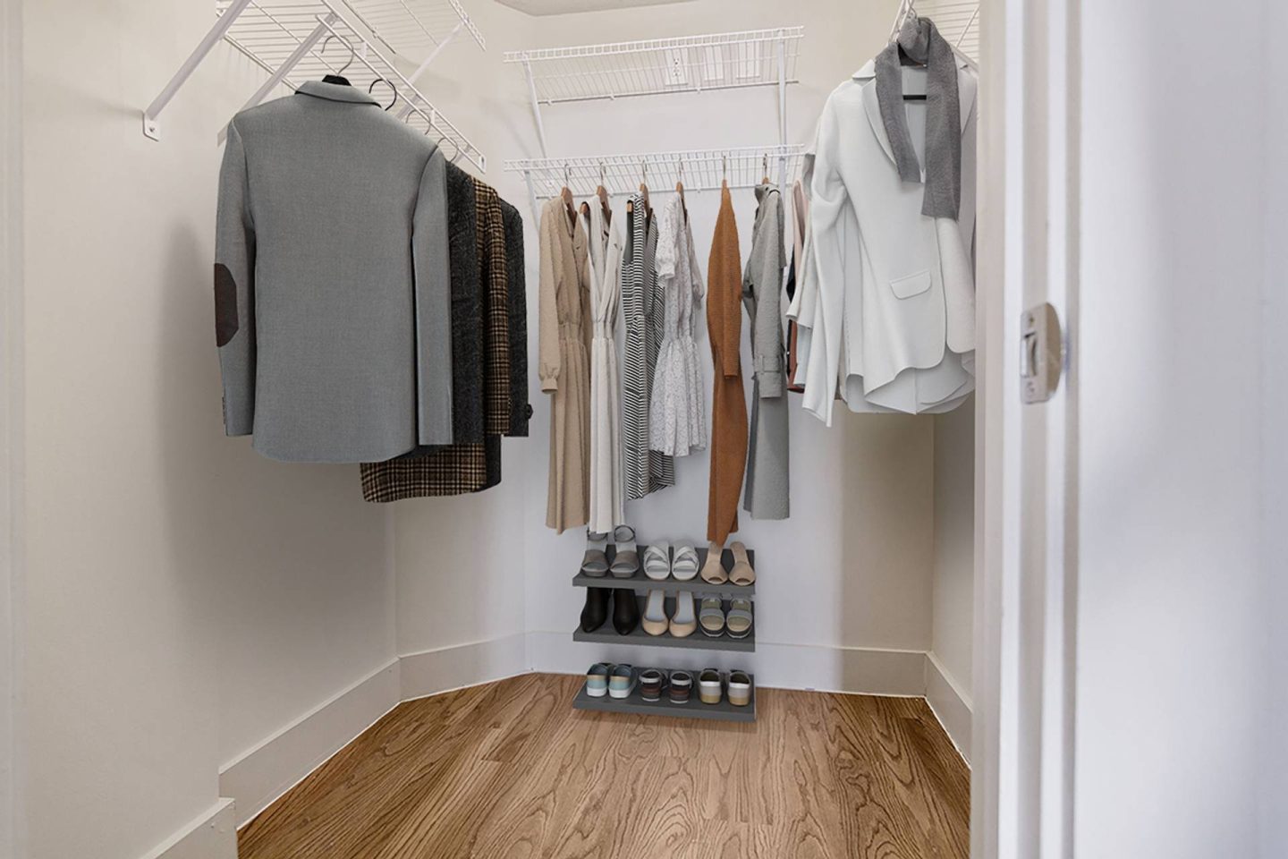A white closet with a grey sweater hanging on the left and a white shirt hanging on the right.