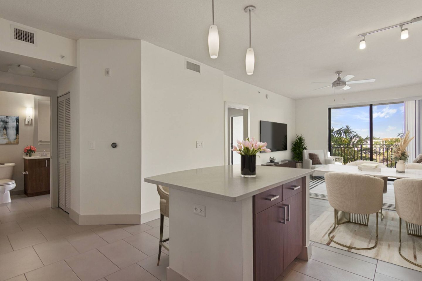 A modern kitchen with a purple island and white chairs.