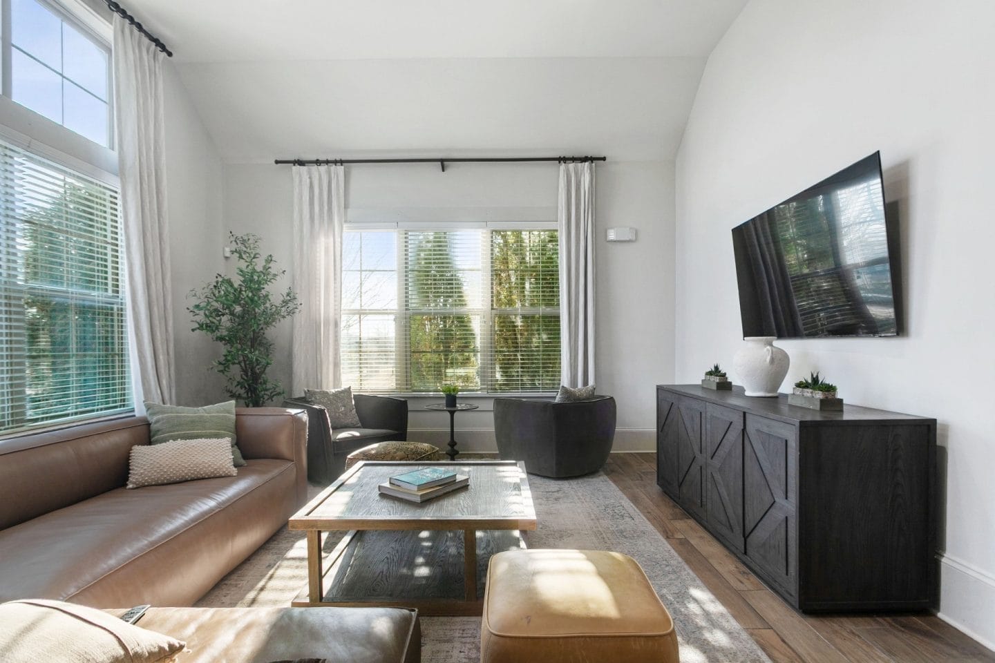 Clubroom TV lounge at Windsor Sugarloaf 1455 Satellite Blvd Suwanee GA 30024 with leather seating wall mounted television large windows and warm natural light