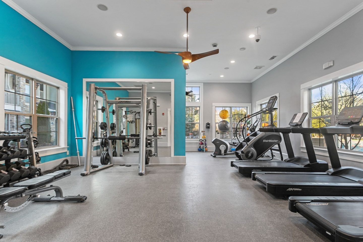 Fitness center at Windsor Sugarloaf 1455 Satellite Blvd Suwanee GA 30024 featuring treadmills stair machines strength equipment and bright windows supporting cardio and full body training