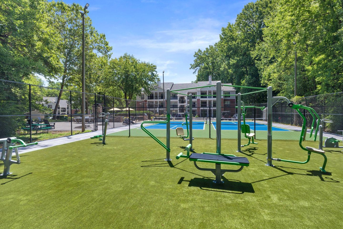 A green grassy area with a playground and a pool.