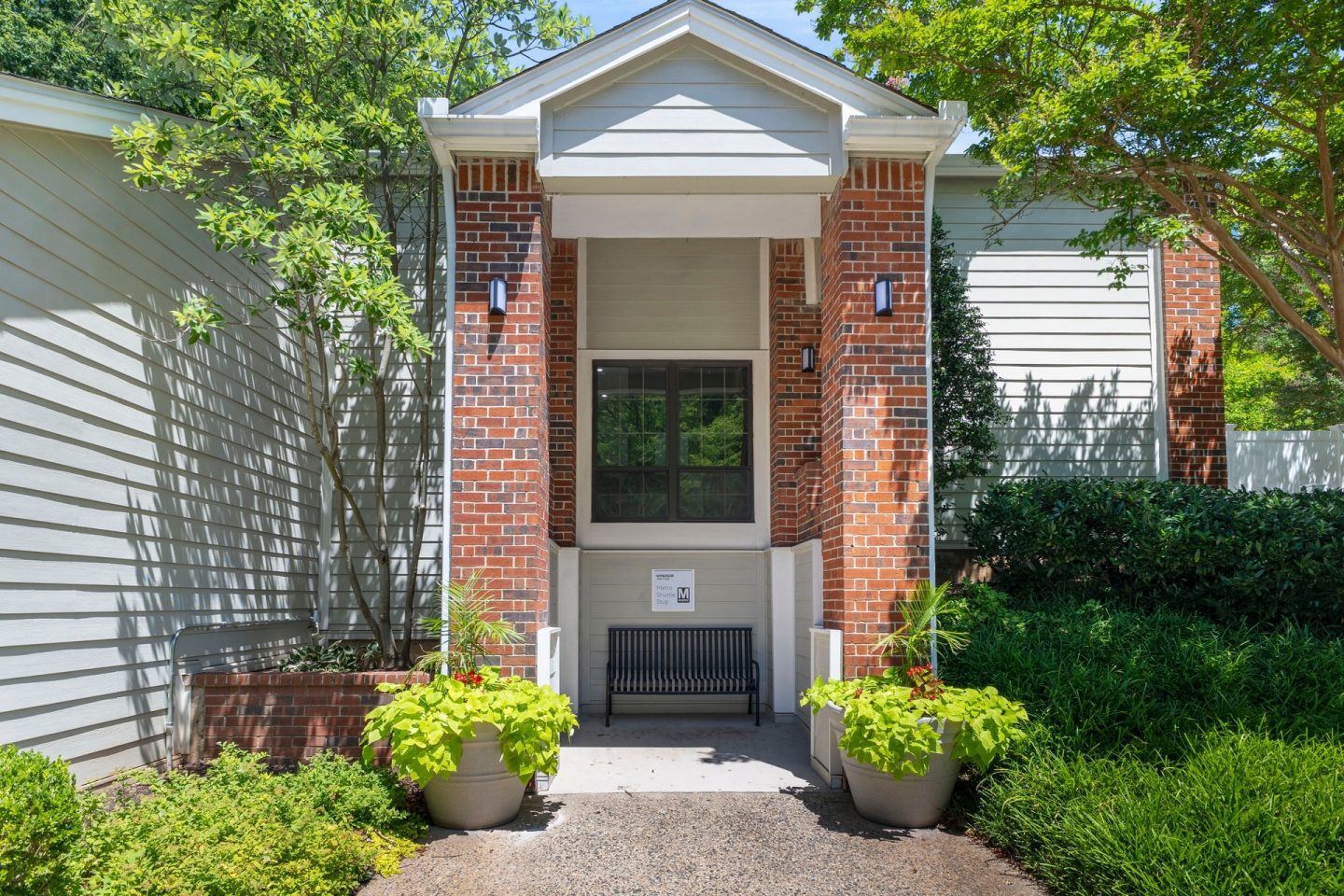A house with a red brick pillar and a white door.