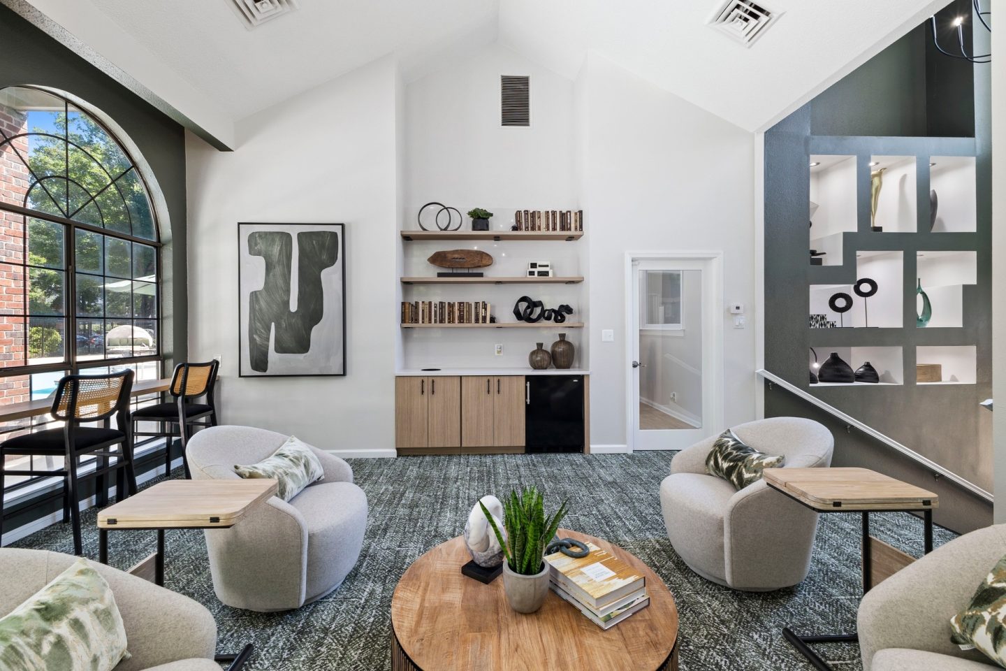 A living room with a large window, a bookshelf, and a couch.