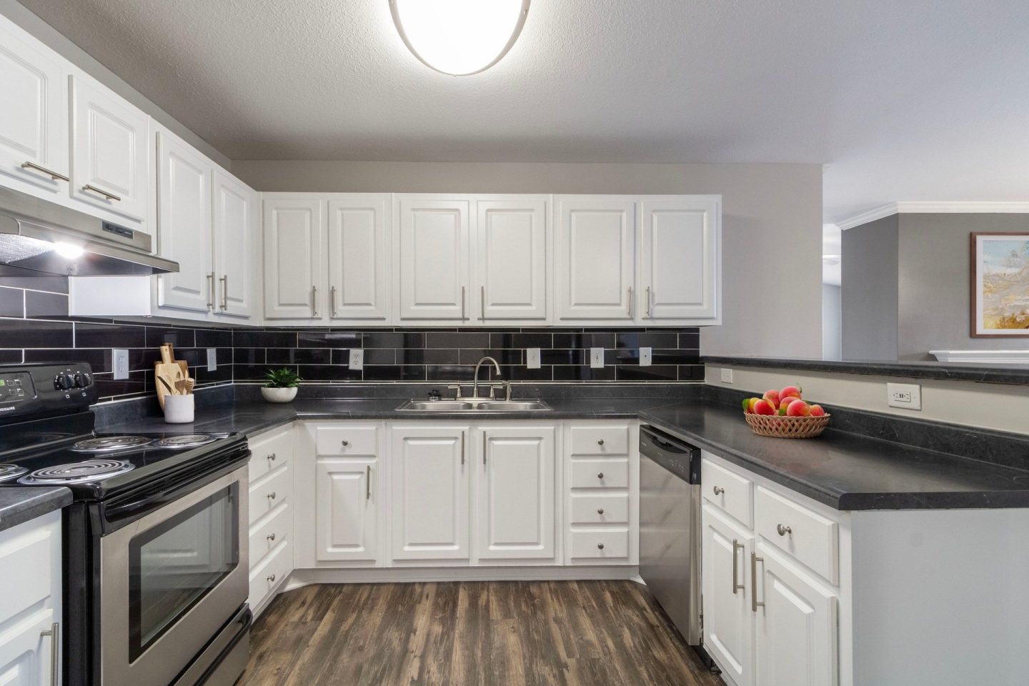 Kitchen corner with white cabinetry, dark countertops, and tile backsplash at Windsor Kennesaw, 1925 Old 41 Highway Northwest, Kennesaw, GA 30152