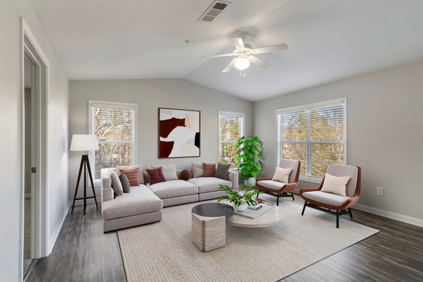 Renovated wide living room with sofa, accent chair, coffee table, and large windows at Windsor Kennesaw, 1925 Old 41 Highway Northwest, Kennesaw, GA 30152