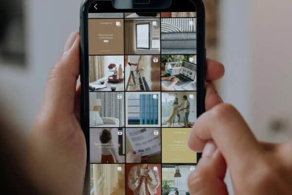 A person is holding a smartphone displaying an Instagram profile for A Beautiful Day brand with a grid of various home decor-related posts.