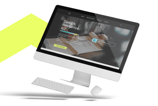 A computer monitor displaying a website homepage with the text "Design. Resilience." and a search bar. A keyboard and mouse are positioned below the monitor on a white background with a yellow geometric graphic behind the setup.