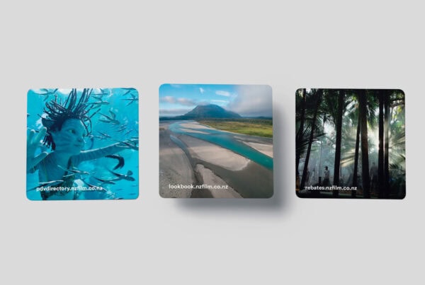 Three square images with text links: a person swimming with fish underwater ("podirectory.nztfiln.co.nz"), a scenic river landscape beneath a blue sky ("lookbook.nztfiln.co.nz"), and sunlight filtering through a dense forest ("rebates.nztfiln.co.nz").