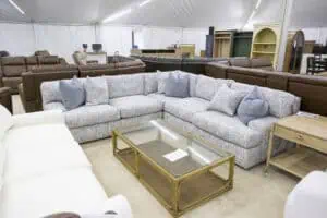 Showcasing a stylish, comfortable sectional sofa in a spacious furniture showroom, perfect for modern living rooms. Explore quality furniture options during the Woodchuck’s Annual Designer Tent Sale 2026.