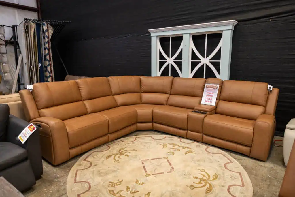 Large tan leather sectional sofa in a furniture store.